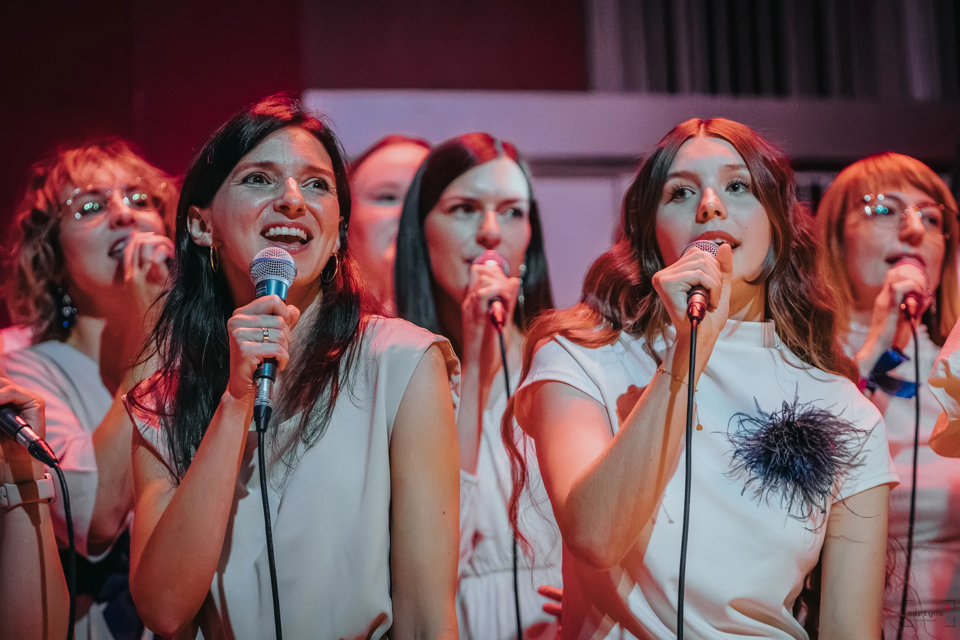 grupa chórzystek 4GOSPEL śpiewających razem do mikrofonów podczas koncertu